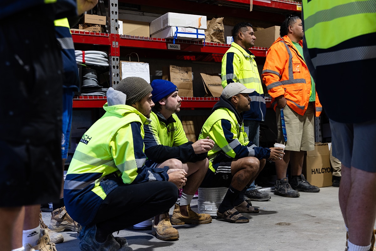 A group of Trades men listening to a team meeting