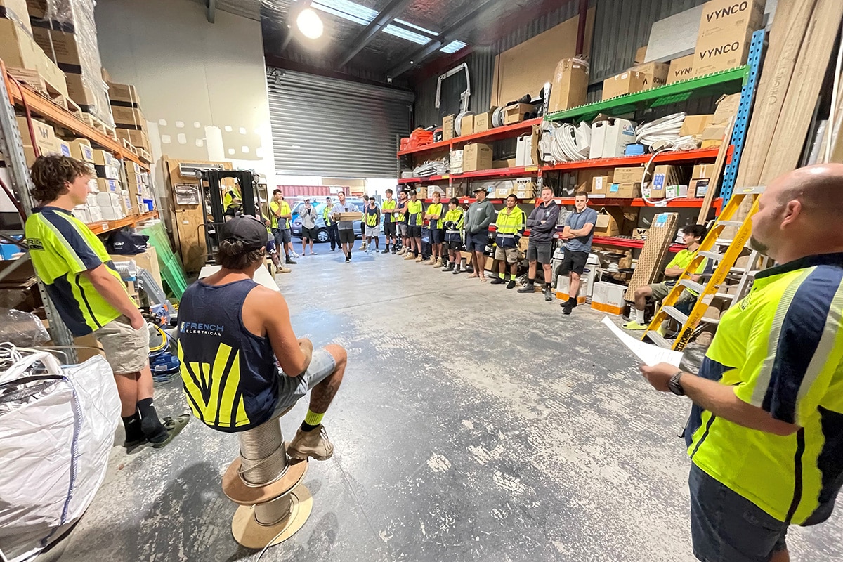 Team of electricians gather for a meeting at the warehouse