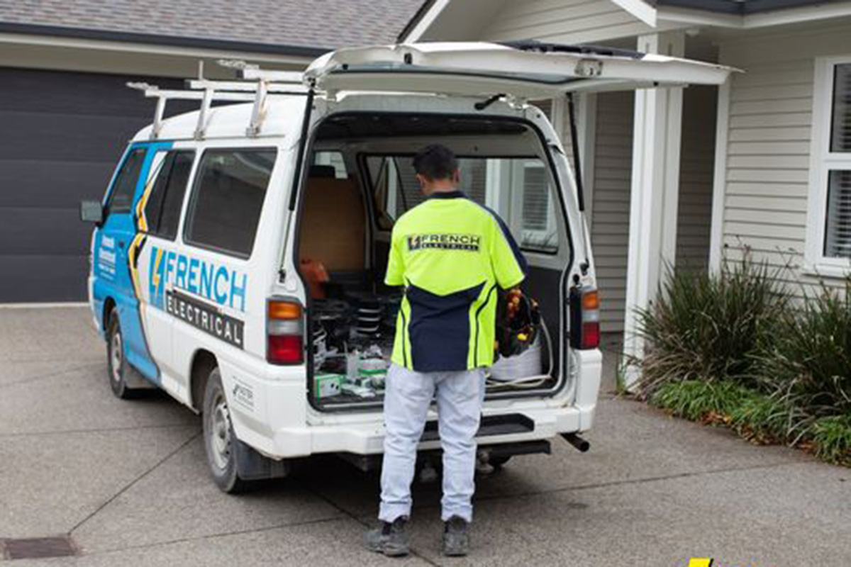 electrician looking through boot of van