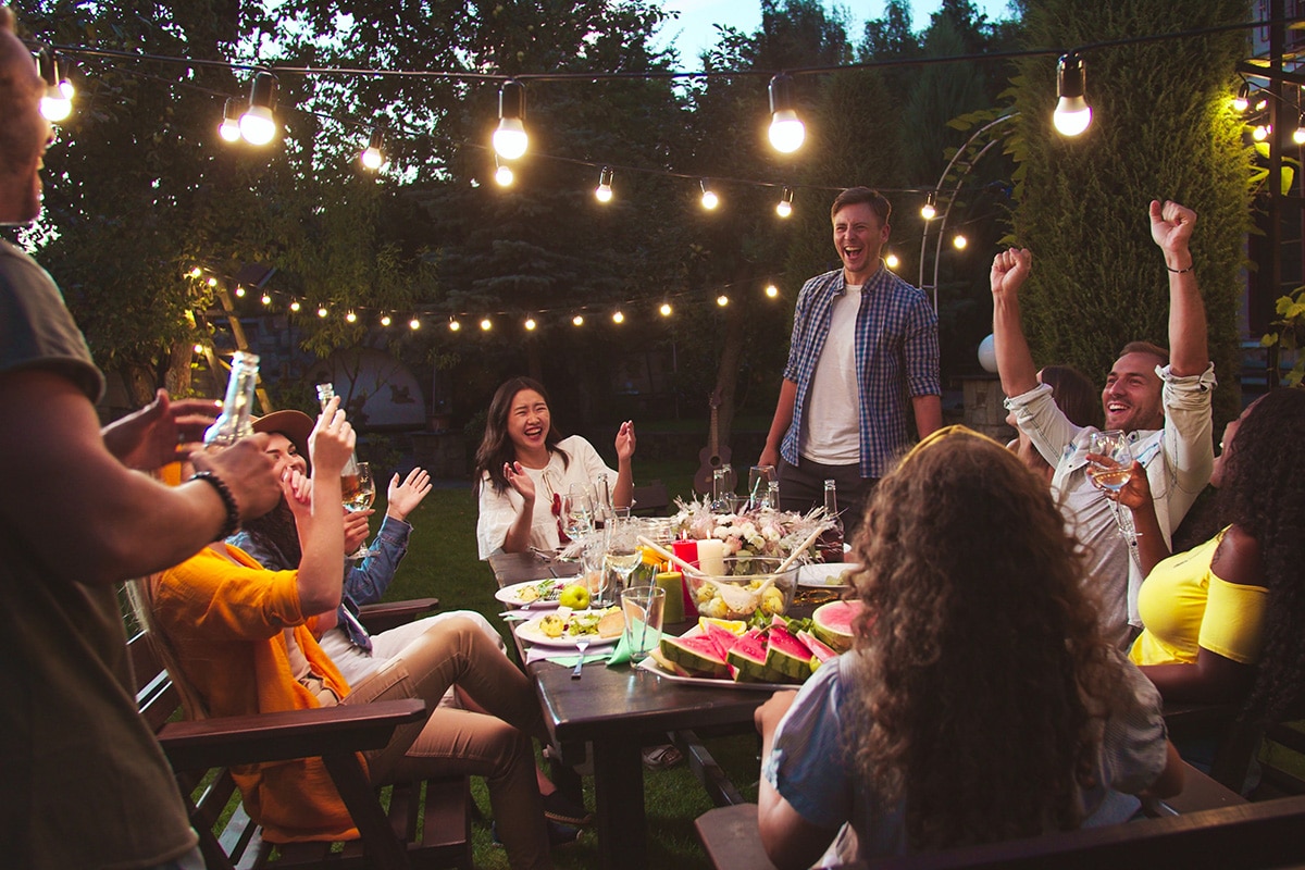 group of friends having a dinner party in outdoor entertaining area