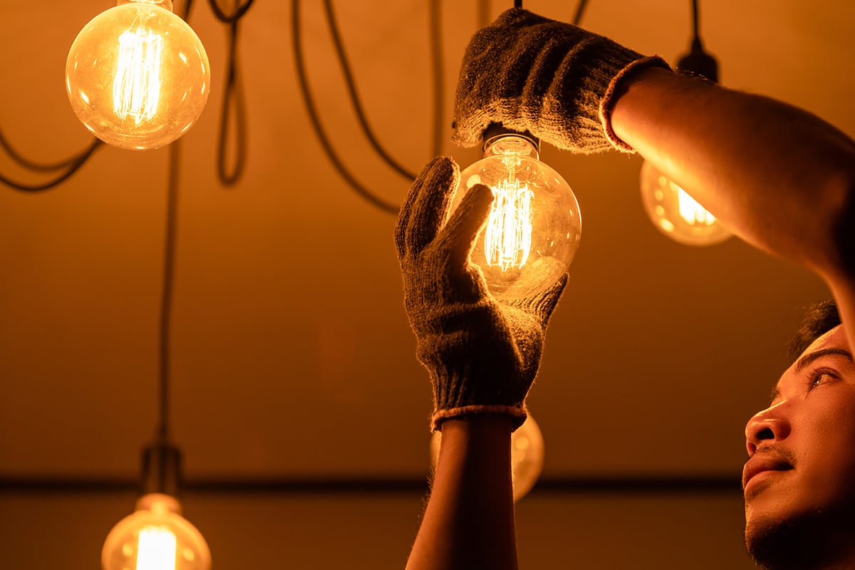 electrician adjusting lightbulb